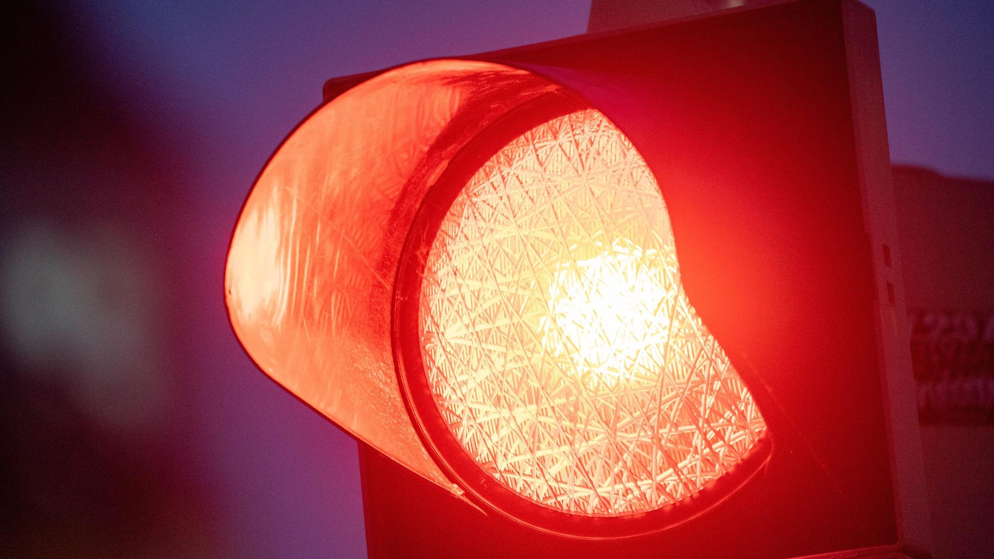 Eine rote Ampel leuchtet am Abend.