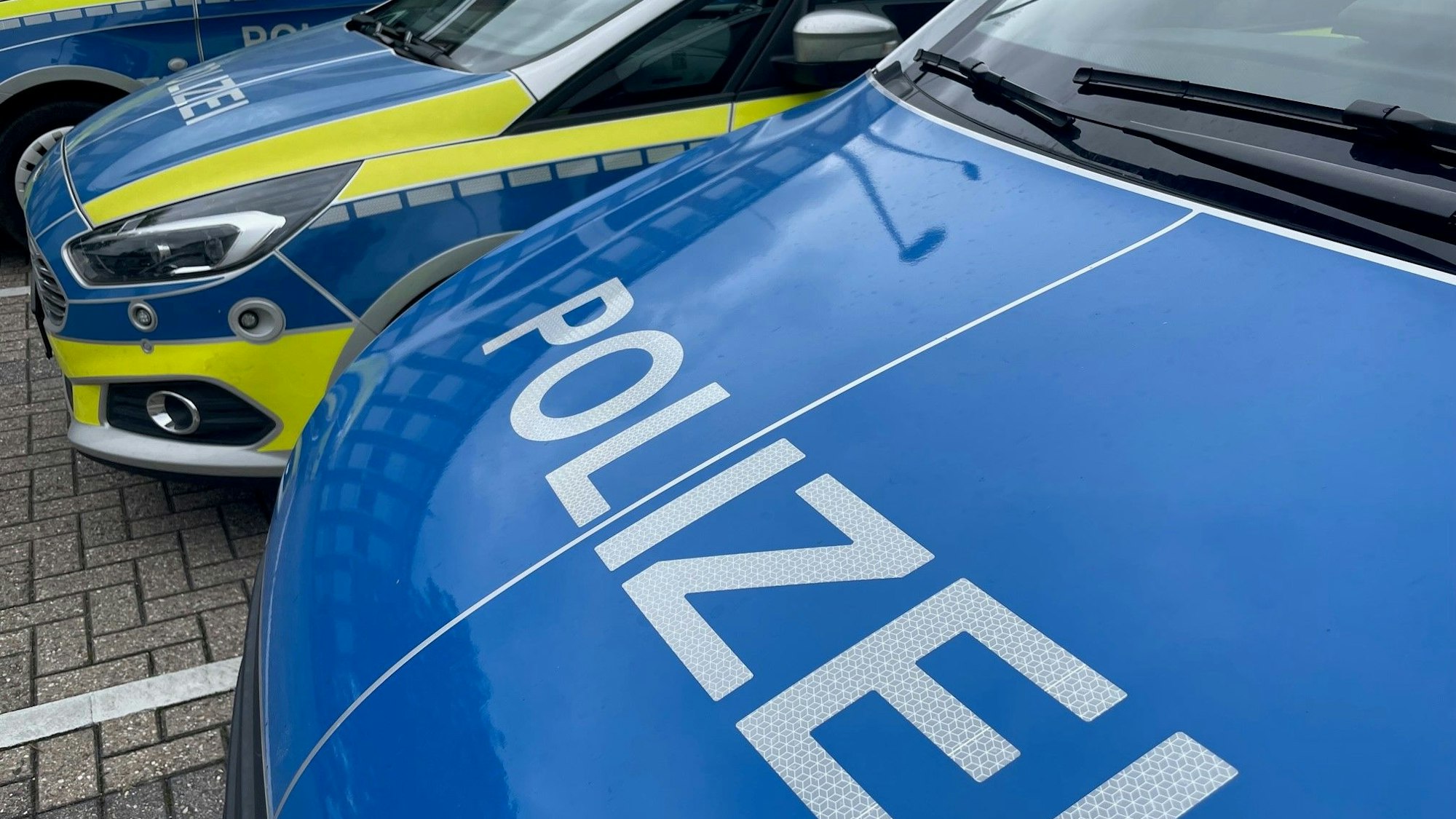 Mehrere Polizeiwagen stehen auf einem Parkplatz.