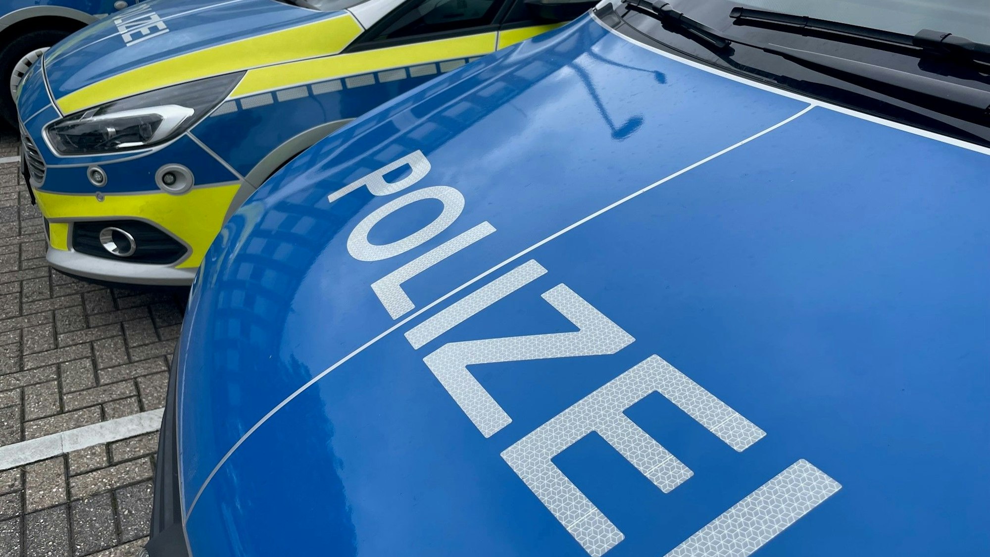 Mehrere Streifenwagen der Polizei stehen auf einem Parkplatz.