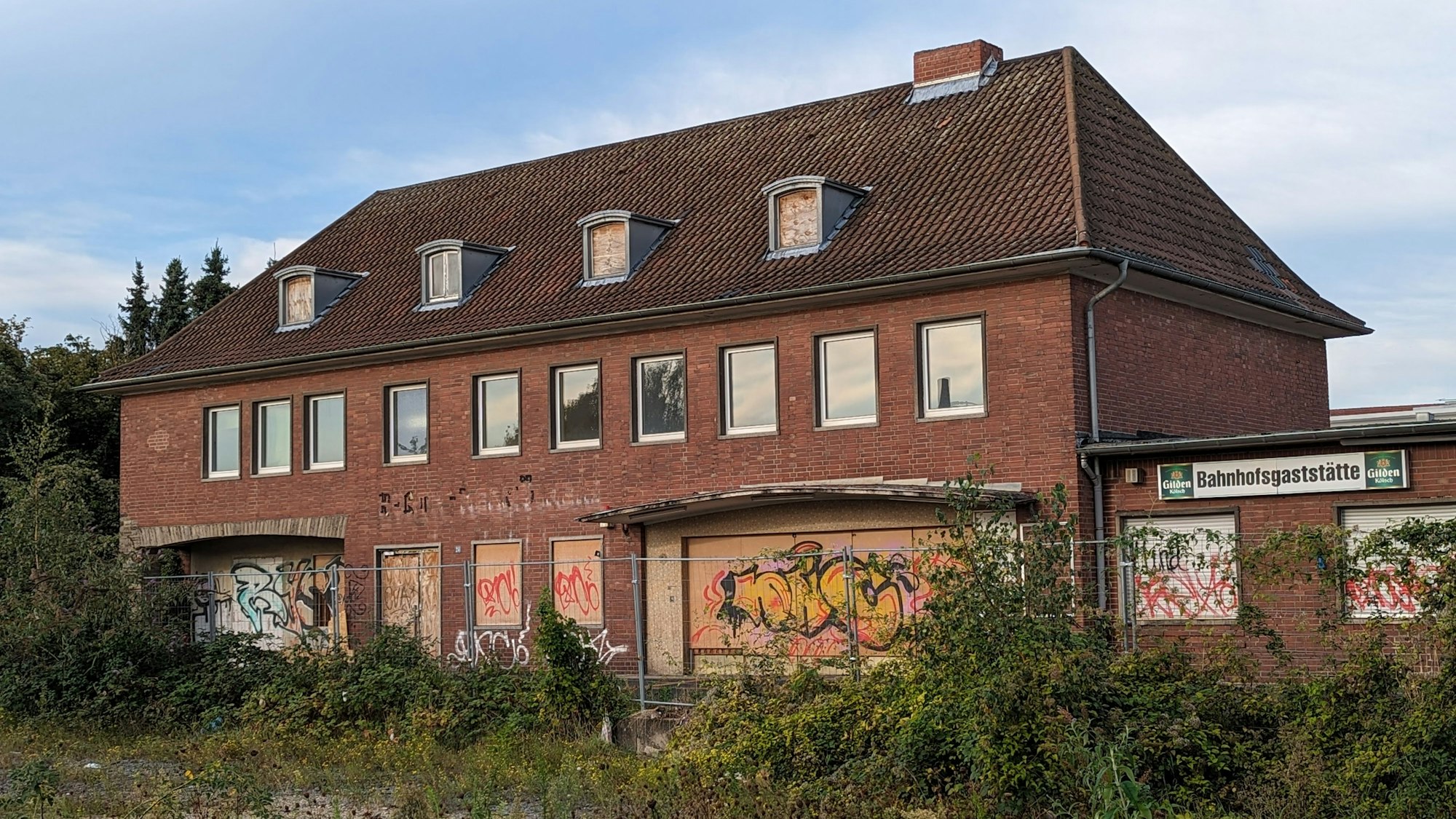 Das Foto zeigt das heruntergekommene alte Bahnhofsgebäude an der Stadtbahn in Hermülheim.