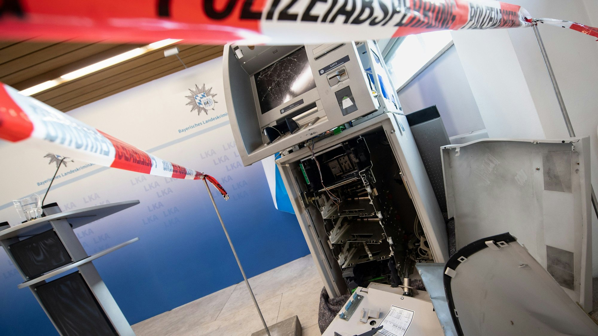 ARCHIV - 15.12.2020, Bayern, München: Ein gesprengter Geldautomat ist auf einer Pressekonferenz beim Landeskriminalamt (LKA) zur Vorstellung des Lagebilds der Organisierten Kriminalität hinter einem Flatterband mit der Aufschrift «Polizeiabsperrung» ausgestellt. (Zu dpa: «Polizei nimmt vier mutmaßliche Geldautomatensprenger fest») Foto: Matthias Balk/dpa +++ dpa-Bildfunk +++