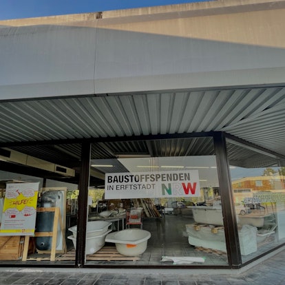 Das Bild zeigt ein Gebäude mit einem Schaufenster, in dem Sanitärwaren zu sehen sind.