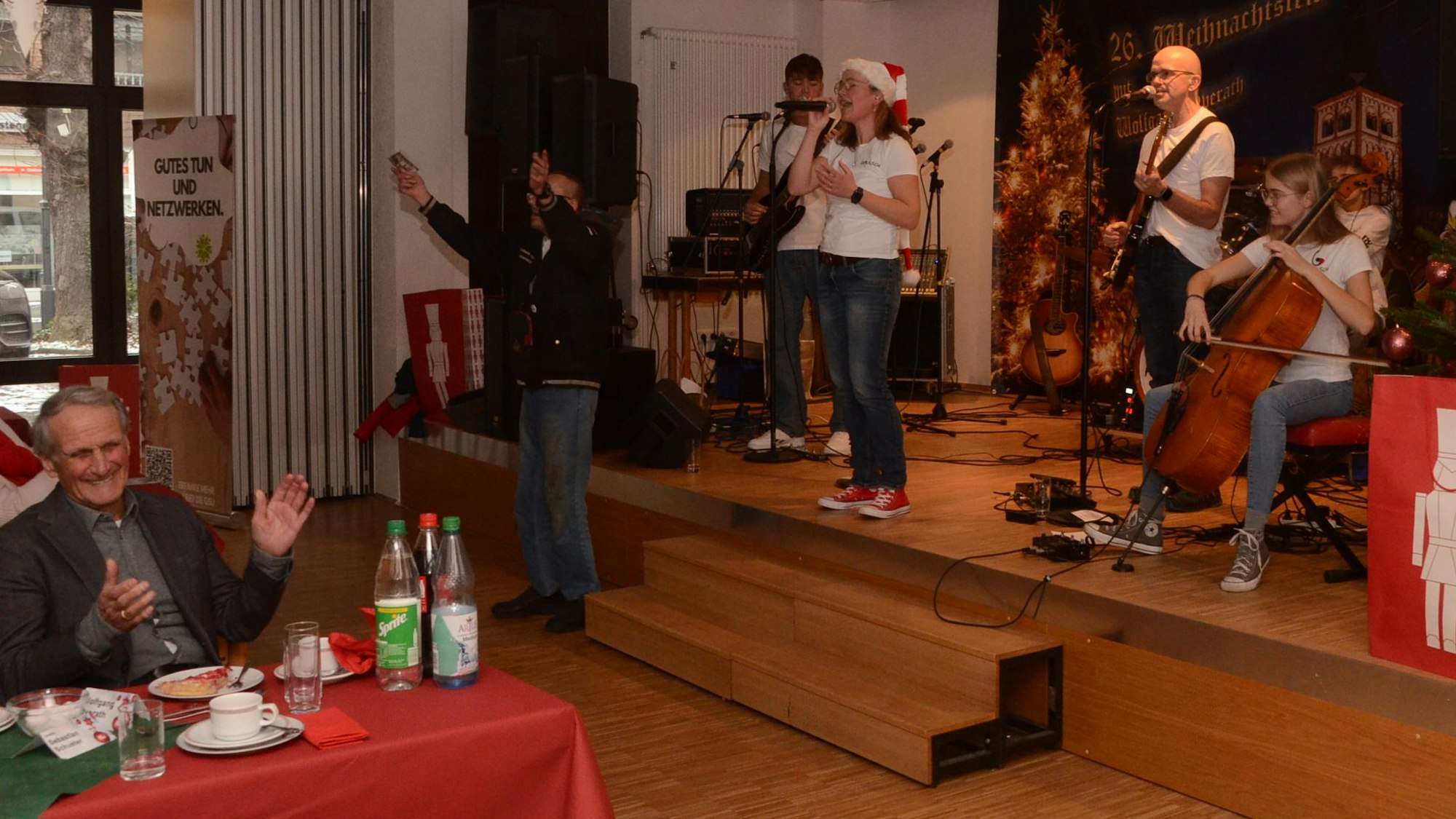 Weihnachtsfeier mit einem Auftritt der Band Famölsch, vorne links an einem Tisch sitzt Wolfgang Overath