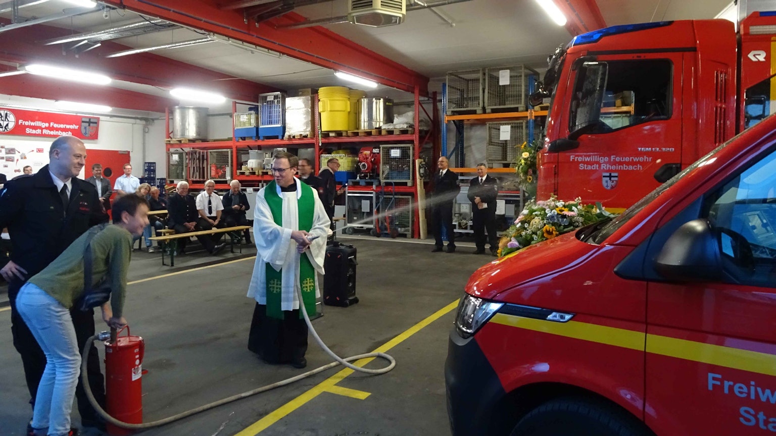 Segnung zweier neuer Feuerwehrfahrzeuge durch Kaplan Stephan Wirgowski von der katholischen Kirchengemeinde St. Martin. An der Kübelspritze pumpt der 13-jährige Patrik von der Rheinbacher Jugendfeuerwehr.