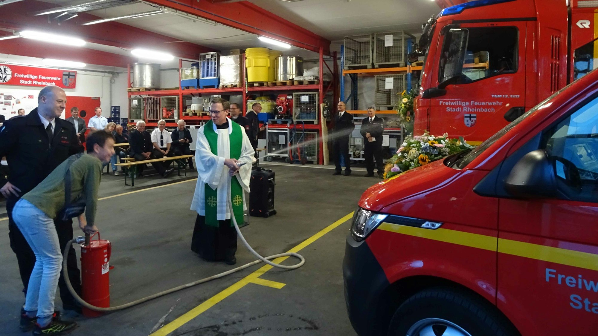 Segnung zweier neuer Feuerwehrfahrzeuge durch Kaplan Stephan Wirgowski von der katholischen Kirchengemeinde St. Martin. An der Kübelspritze pumpt der 13-jährige Patrik von der Rheinbacher Jugendfeuerwehr.