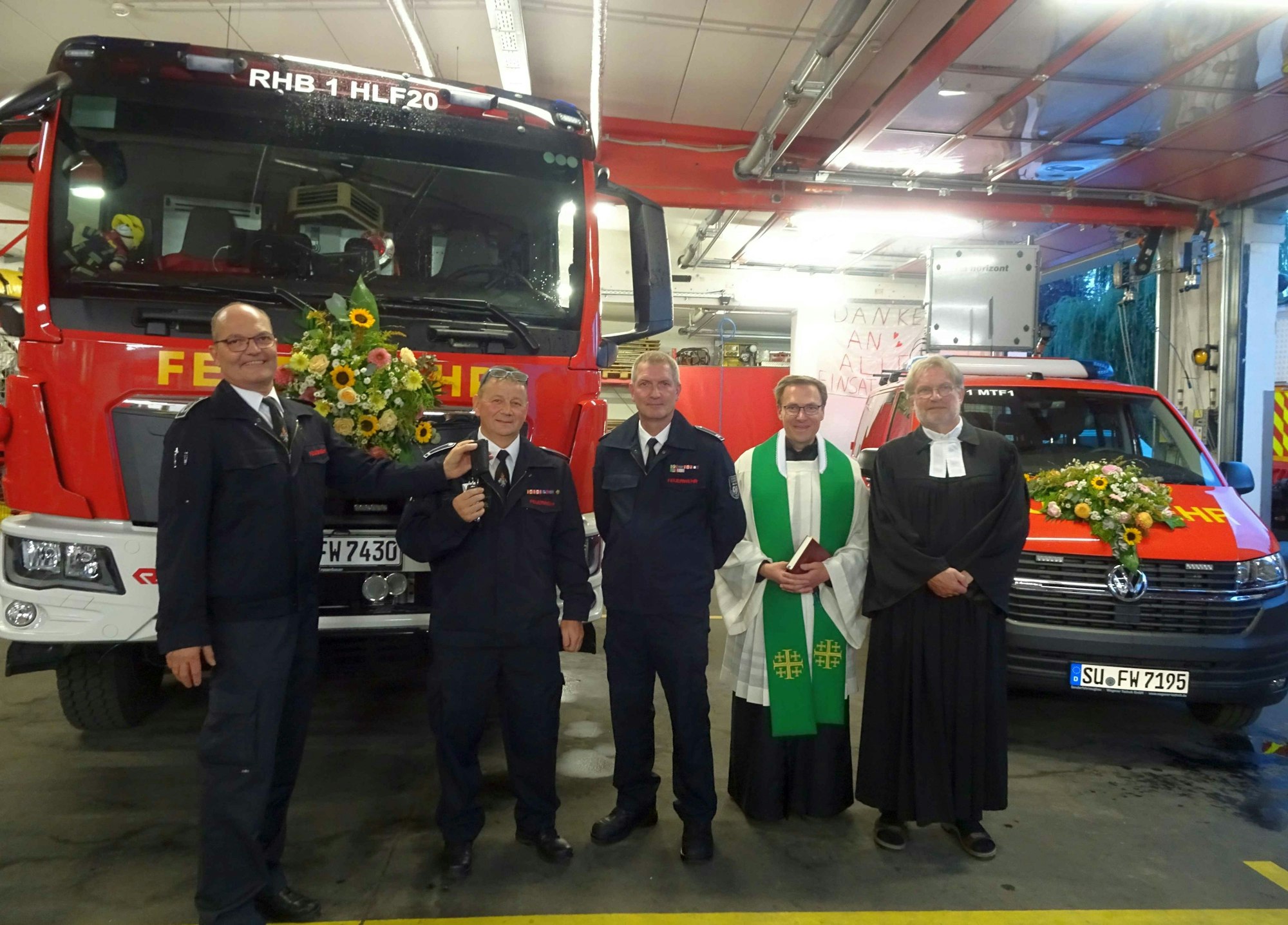 Wehrleiter Jörg Kirchhartz (links) übergibt den Schlüssel für die zwei neuen Feuerwehrfahrzeuge offiziell an Thomas Gundlach, Löschzugführer bei der Freiwilligen Feuerwehr Rheinbach. Daneben der stellvertretende Löschzugführer Rainer Girkens, Kaplan Stephan Wirgowski und der evangelische Pfarrer Dr. Diethard Römheld.