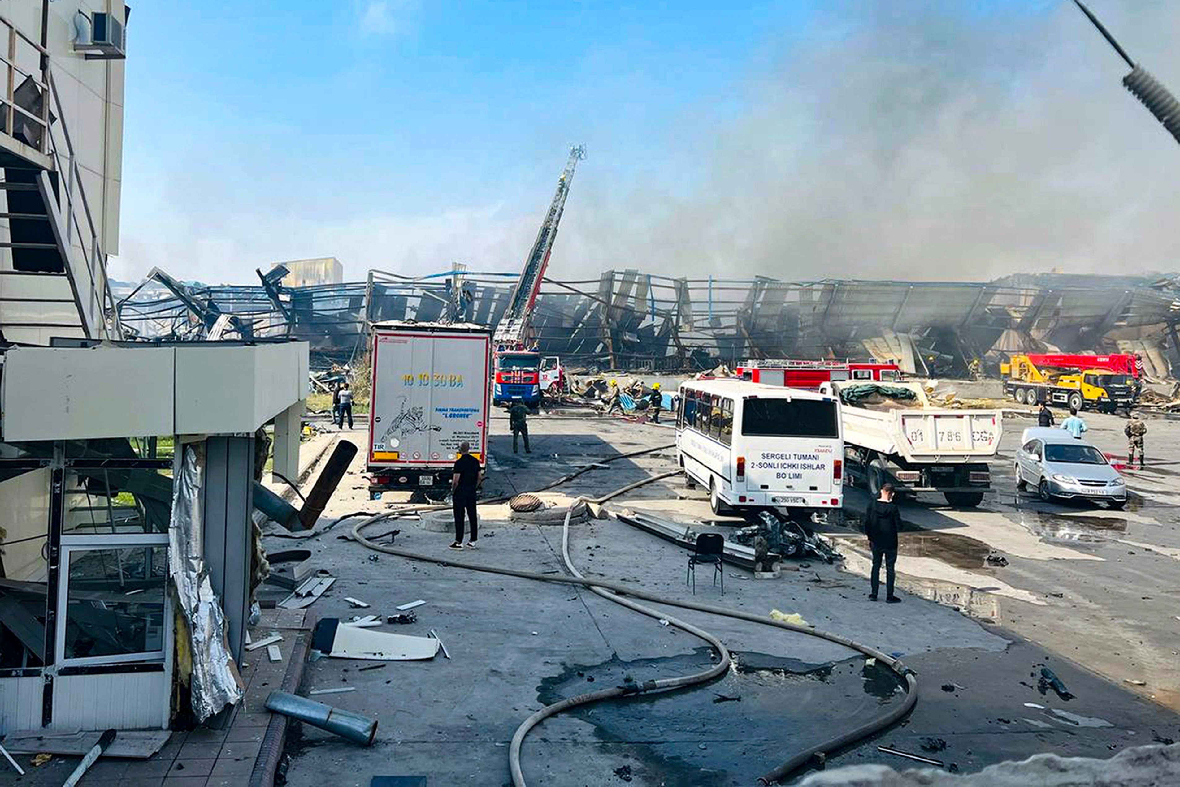 Feuerwehrleute arbeiten daran, ein Feuer in einer Lagerhalle  zu löschen.