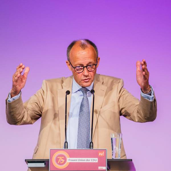 Der CDU-Vorsitzende Friedrich Merz hebt bei einer Rede beide Arme nach oben und gestikuliert vor einem Rednerpult.