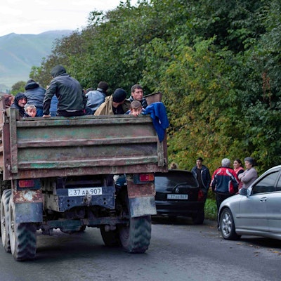 26.09.2023, Aserbaidschan, Goris: Ethnische Armenier aus Berg-Karabach sitzen in einem Lastwagen auf dem Weg nach Goris in der Region Syunik. Nach der Eroberung des Gebietes Berg-Karabach durch Aserbaidschan wächst die Zahl der nach Armenien flüchtenden Menschen . Foto: Gayane Yenokyan/AP/dpa +++ dpa-Bildfunk +++