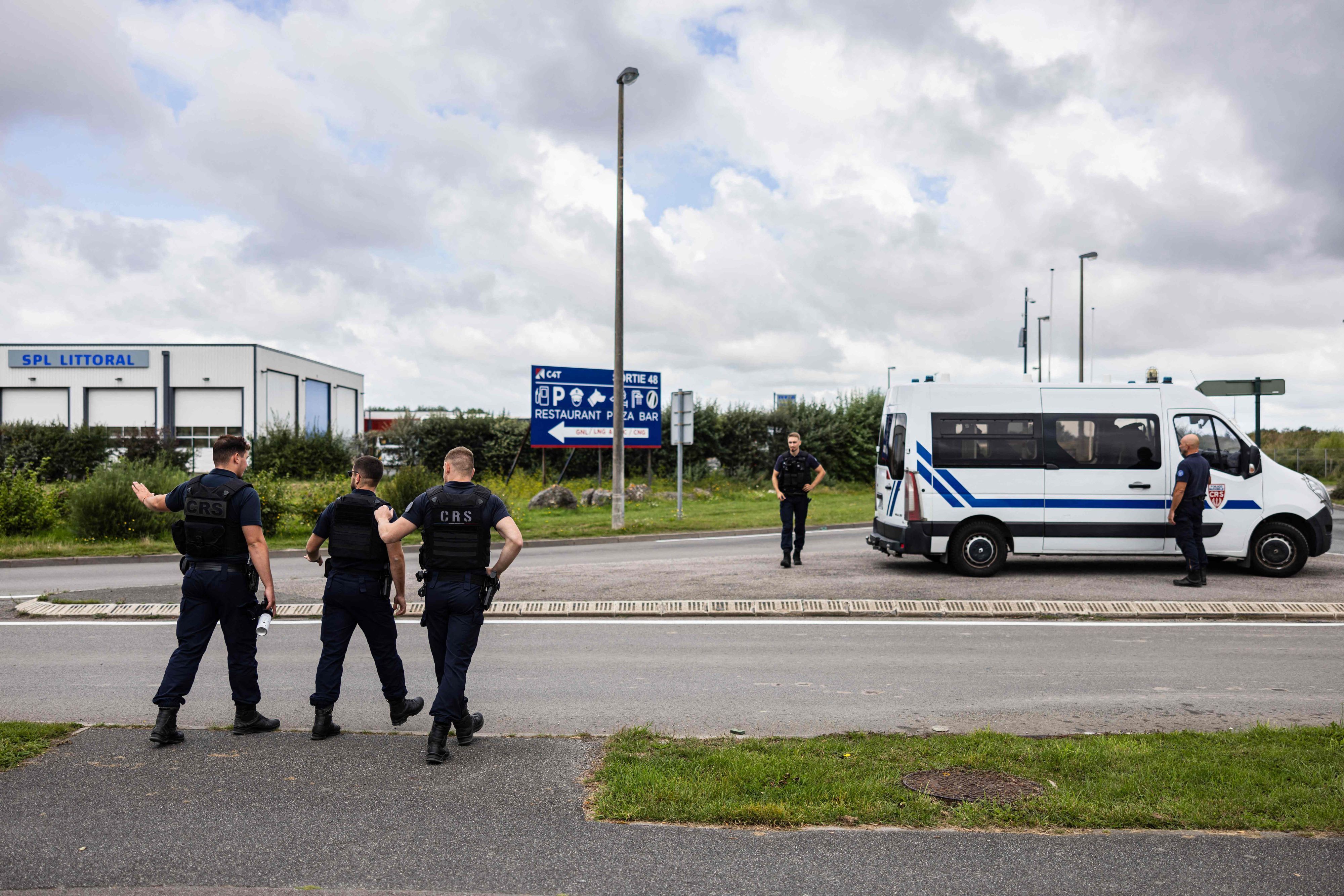 French Republican Security Corps (CRS - Compagnies Republicaines de Securite) police officers, control lorries as they search for migrants near a lorry parking in Marck, northern France on August 28, 2023. All along the 130 km or so of coastline between Dunkirk and the Bay of the Somme, and even as far as Normandy, the authorities are combing the land and sky to try and stop people heading for the English coast. (Photo by Sameer Al-DOUMY / AFP)