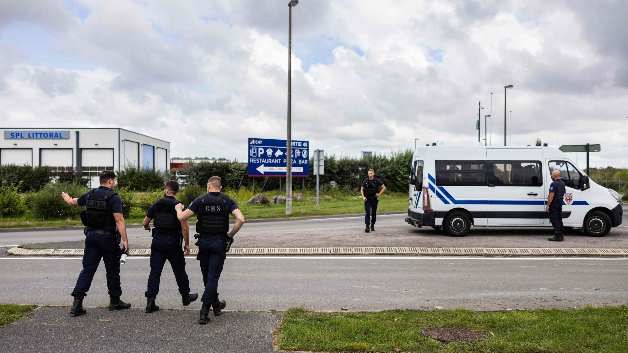 French Republican Security Corps (CRS - Compagnies Republicaines de Securite) police officers, control lorries as they search for migrants near a lorry parking in Marck, northern France on August 28, 2023. All along the 130 km or so of coastline between Dunkirk and the Bay of the Somme, and even as far as Normandy, the authorities are combing the land and sky to try and stop people heading for the English coast. (Photo by Sameer Al-DOUMY / AFP)