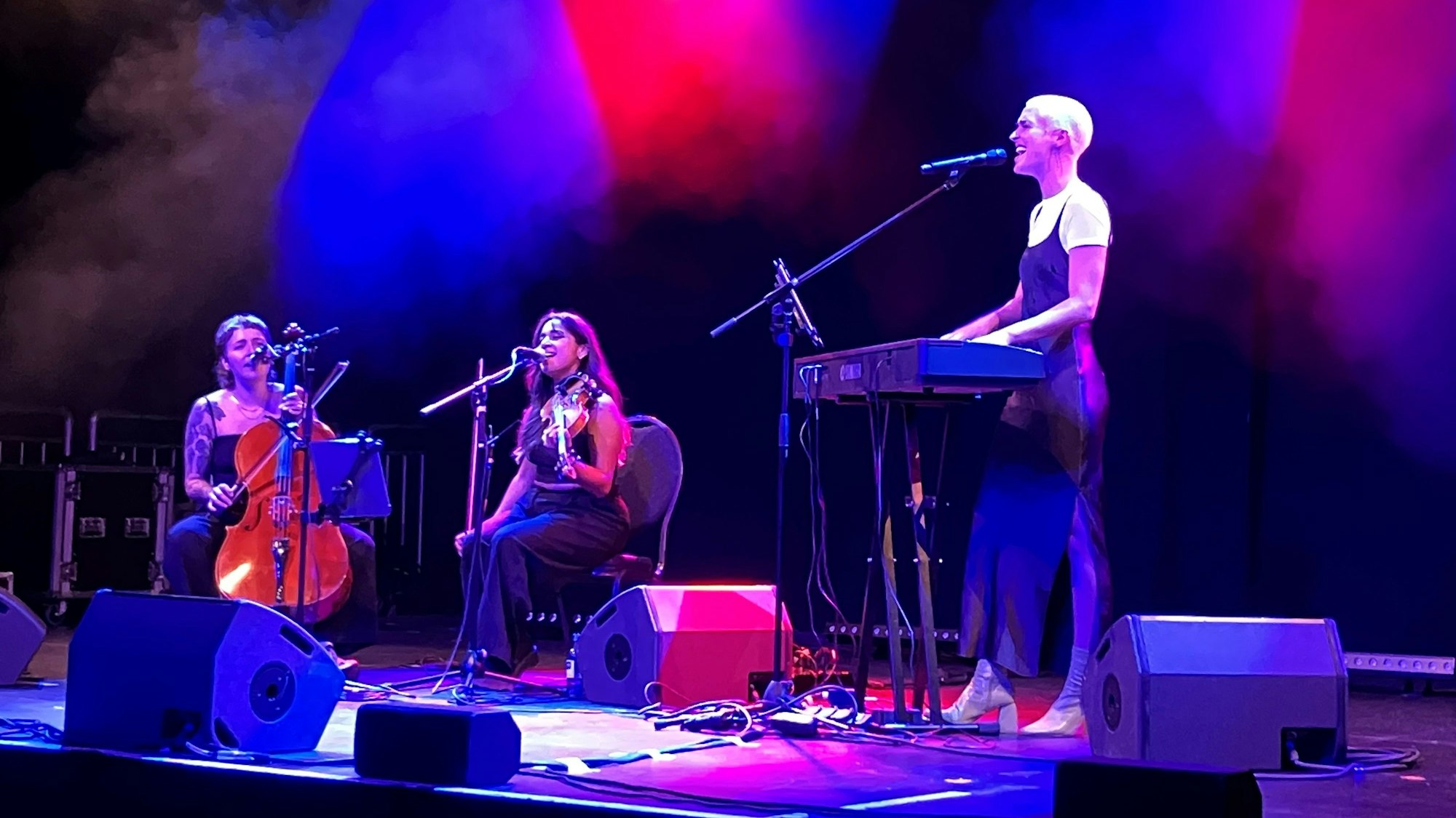 Drei Musikerinnen auf einer Bühne am Keyboard, Geige und Cello.