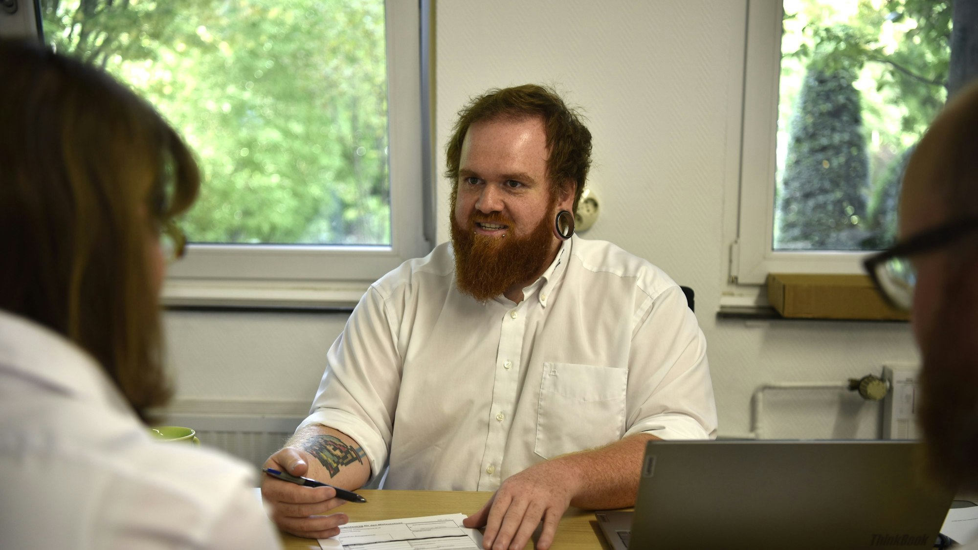 Ein Mann sitzt an einem Schreibtisch, vor ihm liegt ein Wohngeldantrag.