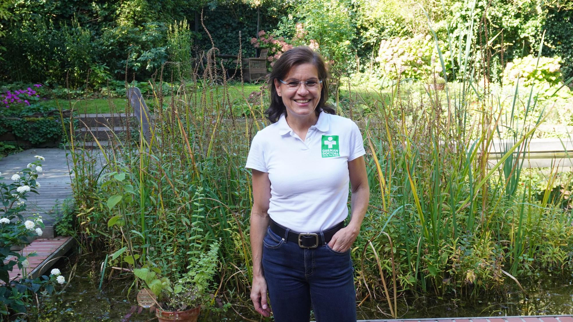 Eine Frau steht im Garten.
