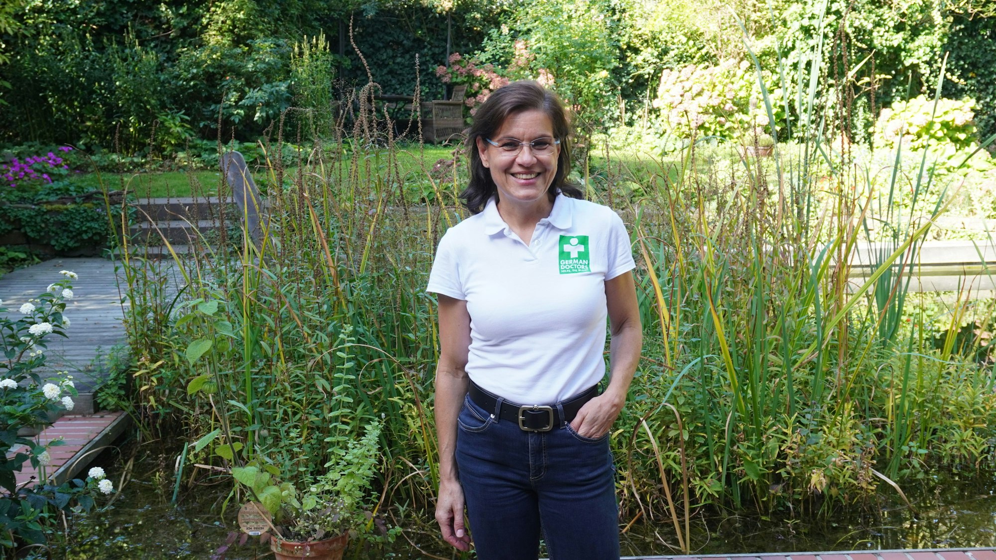 Eine Frau steht im Garten.