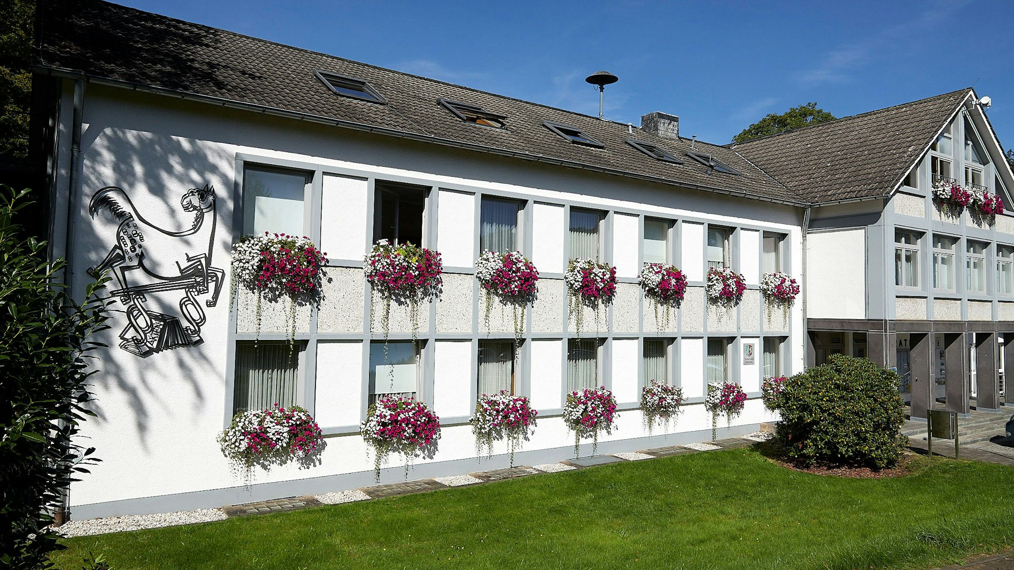 Ein Amtsschimmel ist auf der linken Seite an der Fassade des Hellenthaler Rathauses zu sehen.