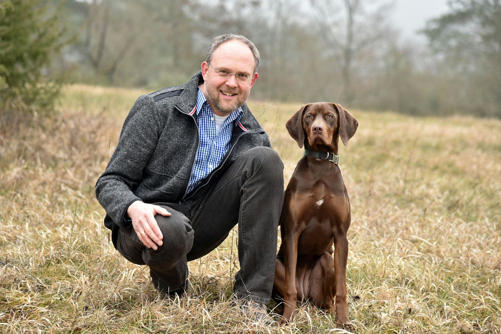 Tierpathologe Achim Gruber posiert mit einem Hund.