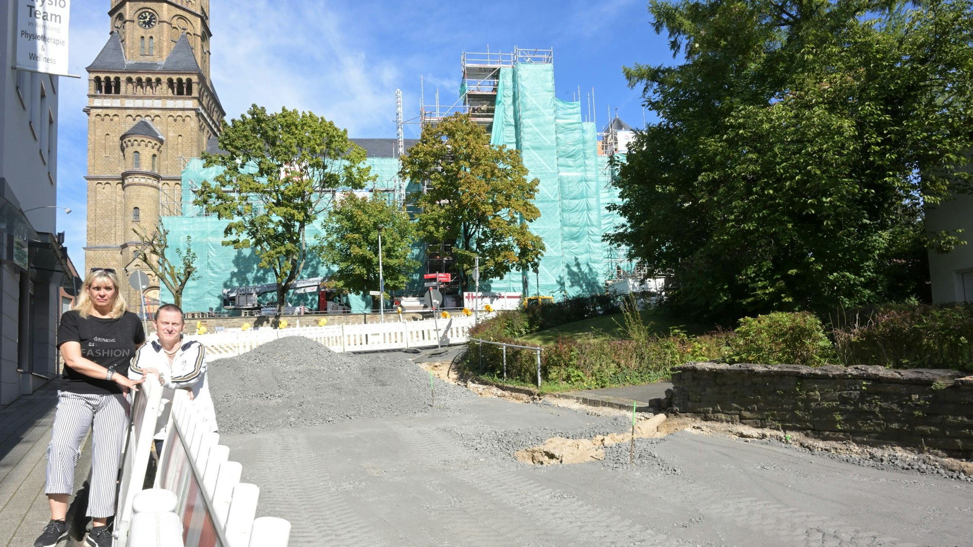 Susanne und Frank Kramm stehen vor einem Bauzaun.