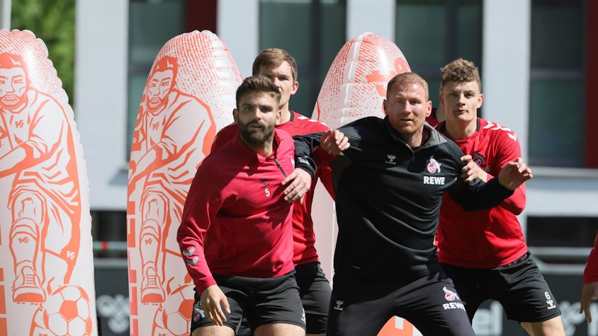 Das Bild zeigt Lukas Sinkiewics zwischen mehreren Spielern vom 1. FC Köln.