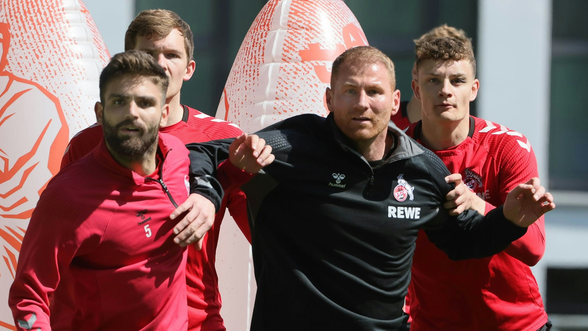 Das Bild zeigt Lukas Sinkiewics zwischen mehreren Spielern vom 1. FC Köln.