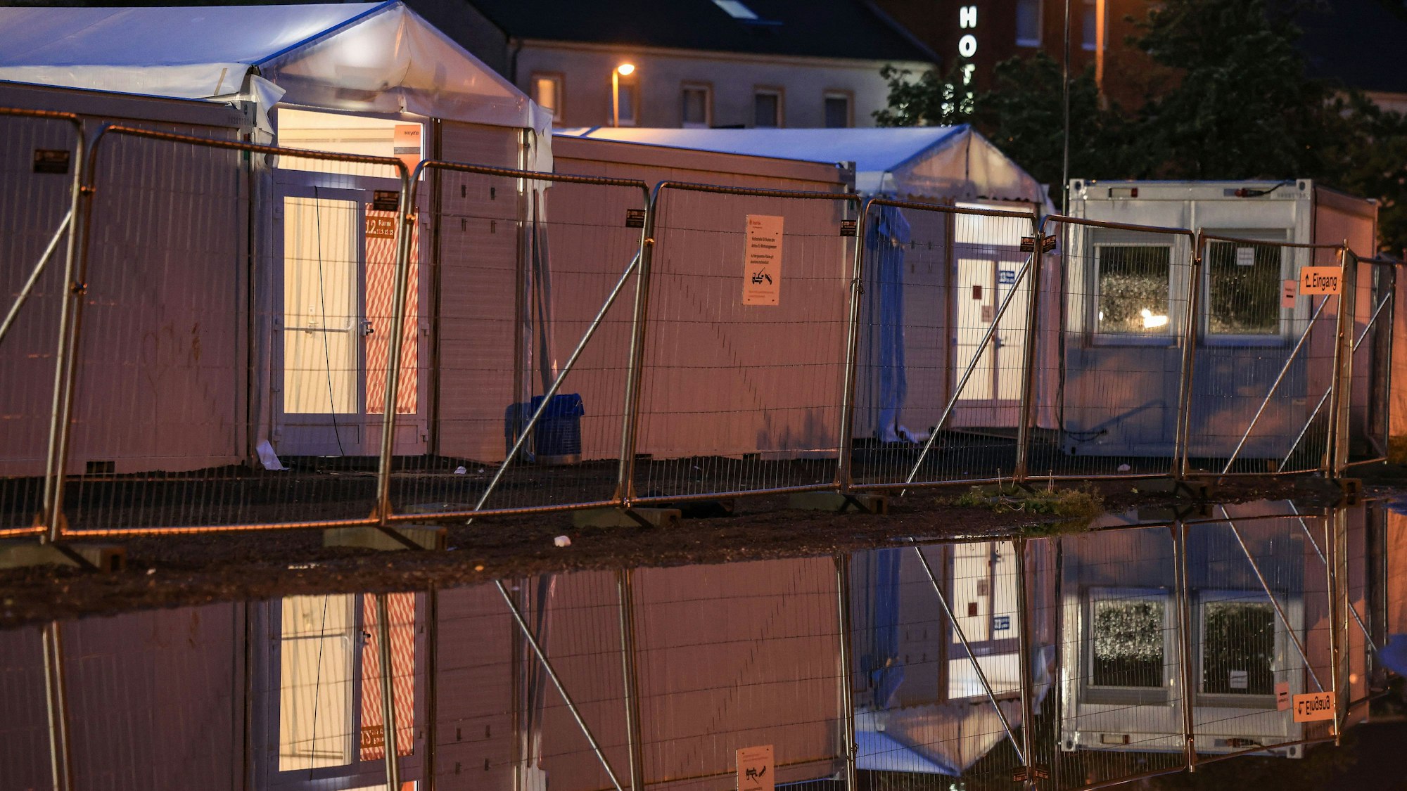 Wohncontainer der kommunalen Erstaufnahmeeinrichtung in Köln-Zollstock sind am Morgen beleuchtet. Das Land Nordrhein-Westfalen will bis Anfang kommenden Jahres 3000 zusätzliche Plätze für die Erstunterbringung von Geflüchteten schaffen. Das sei Ergebnis eines Gesprächs, an dem unter anderem Ministerpräsident Hendrik Wüst (CDU) und Vertreter der kommunalen Spitzenverbände teilnahmen, wie die Staatskanzlei am Freitag mitteil