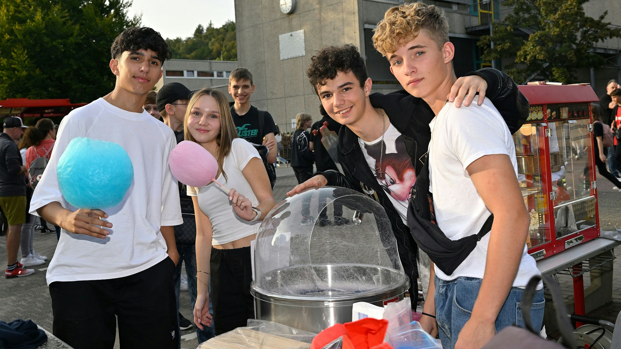 Vier Jugendliche essen bunte Zuckerwatte.