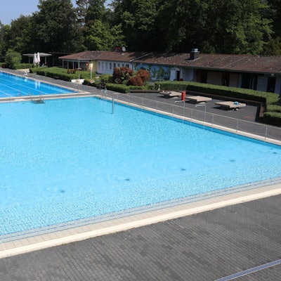 Das Bild zeigt das Nichtschwimmer- und das 50-Meter-Becken des Lemmerz-Freibades. Die Becken sind mit Wasser gefüllt.