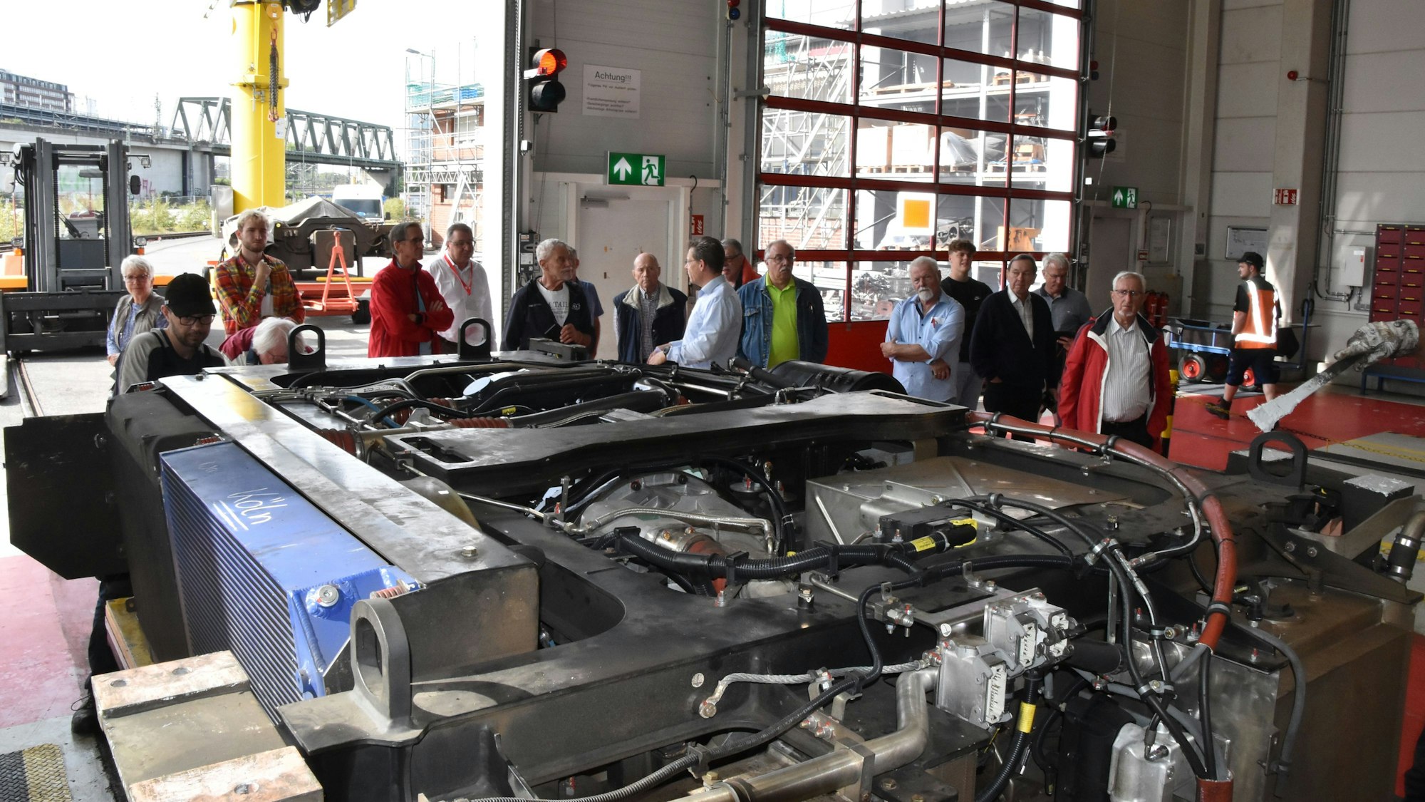Leser stehen rund um den großen Motor eines Dieseltriebzuges.