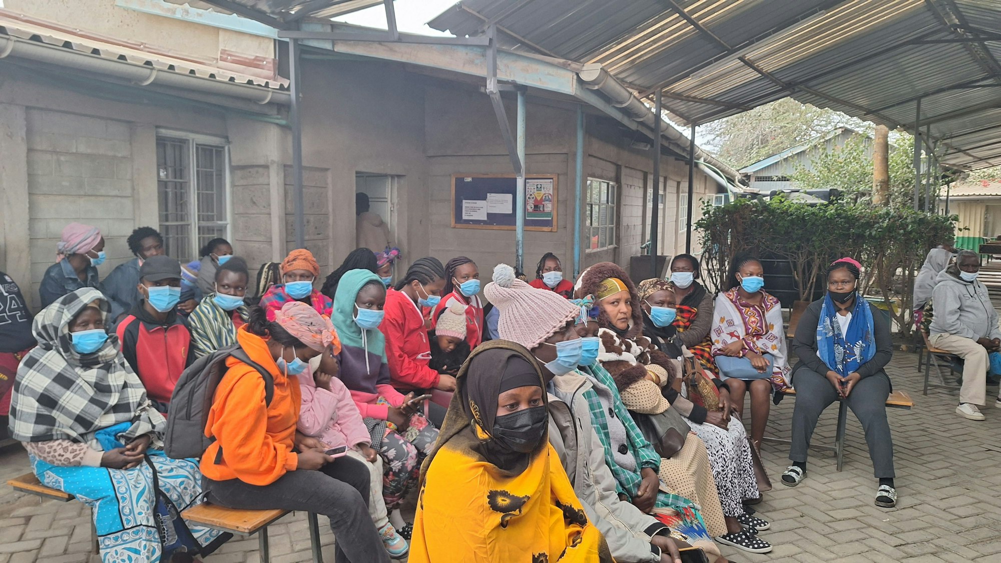 Menschen sitzen auf Bänke und warten.