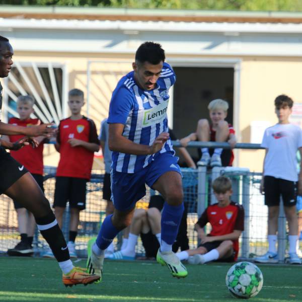Das Bild zeigt den Fußballer Deniz Isitmen im Laufduell mit einem Gegenspieler.