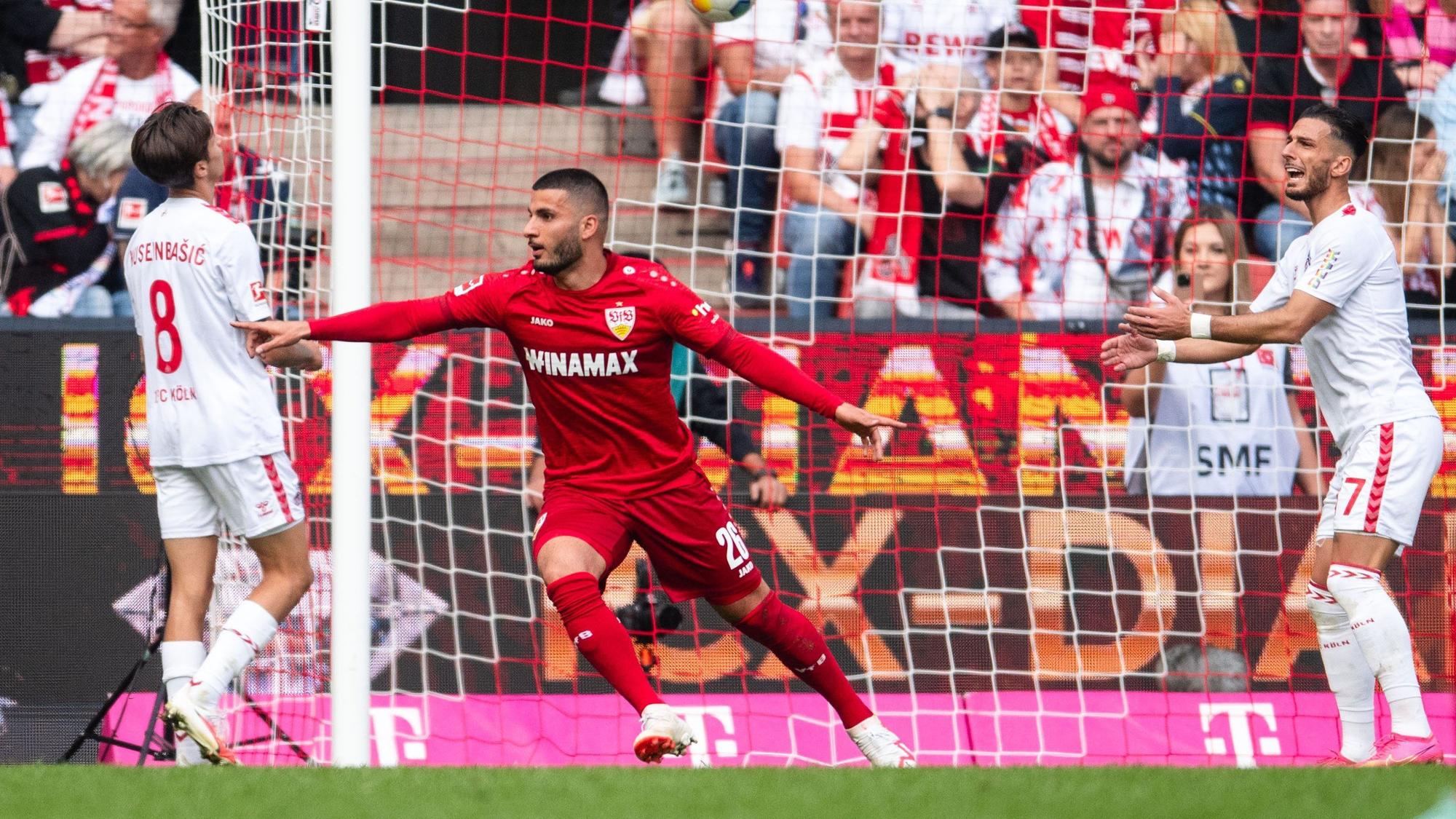 30.09.2023, Nordrhein-Westfalen, Köln: Fußball: Bundesliga, 1. FC Köln - VfB Stuttgart, 6. Spieltag, RheinEnergieStadion. Stuttgarts Torschütze Deniz Undav (M) jubelt nach seinem Treffer zum 1:0. Links Kölns Denis Huseinbasic und rechts Leart Paqarada.