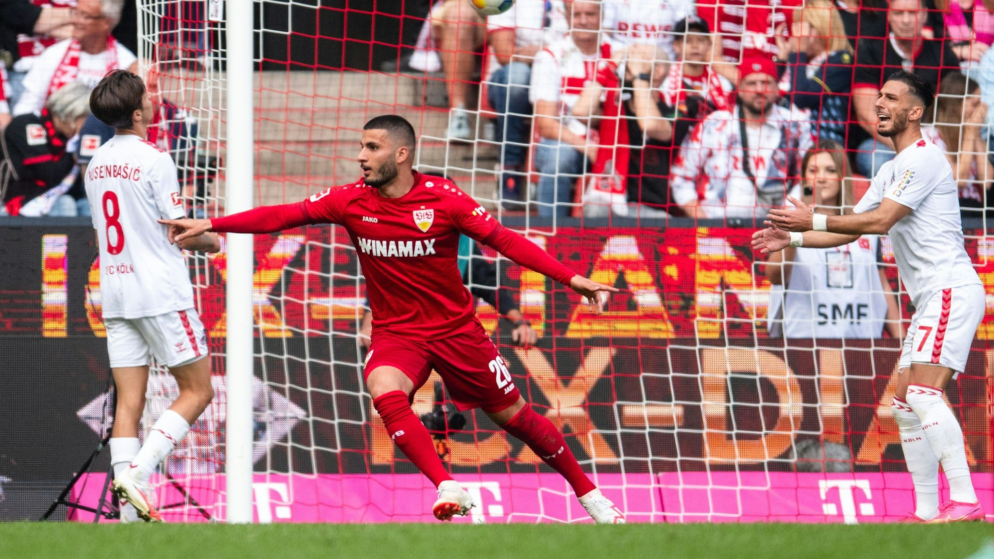 30.09.2023, Nordrhein-Westfalen, Köln: Fußball: Bundesliga, 1. FC Köln - VfB Stuttgart, 6. Spieltag, RheinEnergieStadion. Stuttgarts Torschütze Deniz Undav (M) jubelt nach seinem Treffer zum 1:0. Links Kölns Denis Huseinbasic und rechts Leart Paqarada.