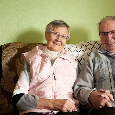 Ida und Karl Kirfel sitzen Hand in Hand auf einem Sofa. Sie sind seit 65 Jahren verheiratet.