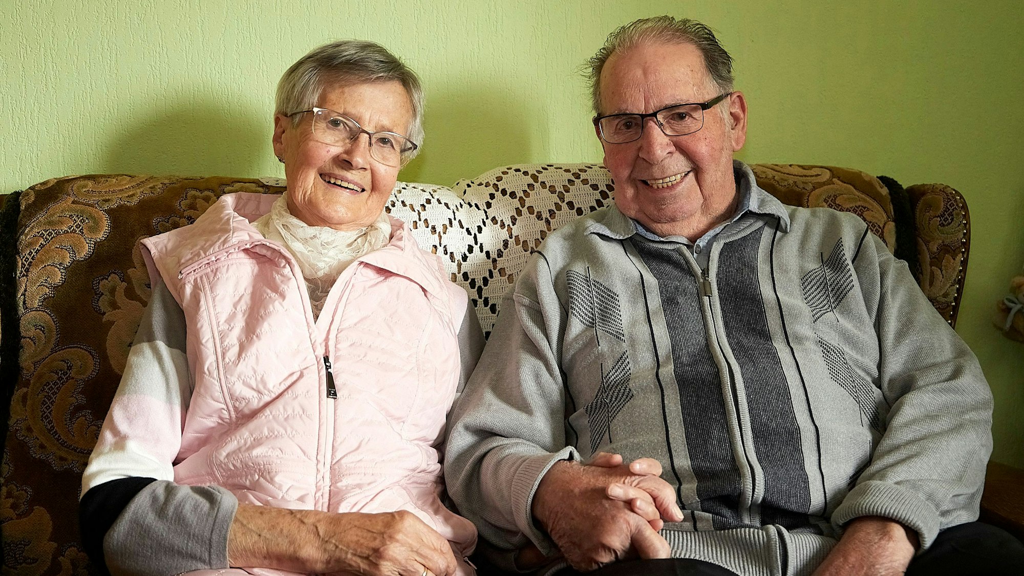 Ida und Karl Kirfel sitzen Hand in Hand auf einem Sofa. Sie sind seit 65 Jahren verheiratet.