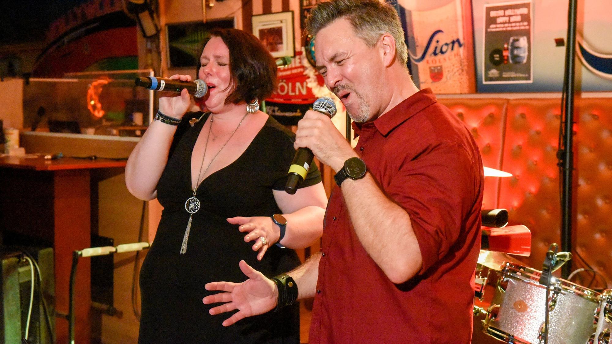 Die Geschwister Marion und Michael Schmitz singen in ihre Mikrofone.