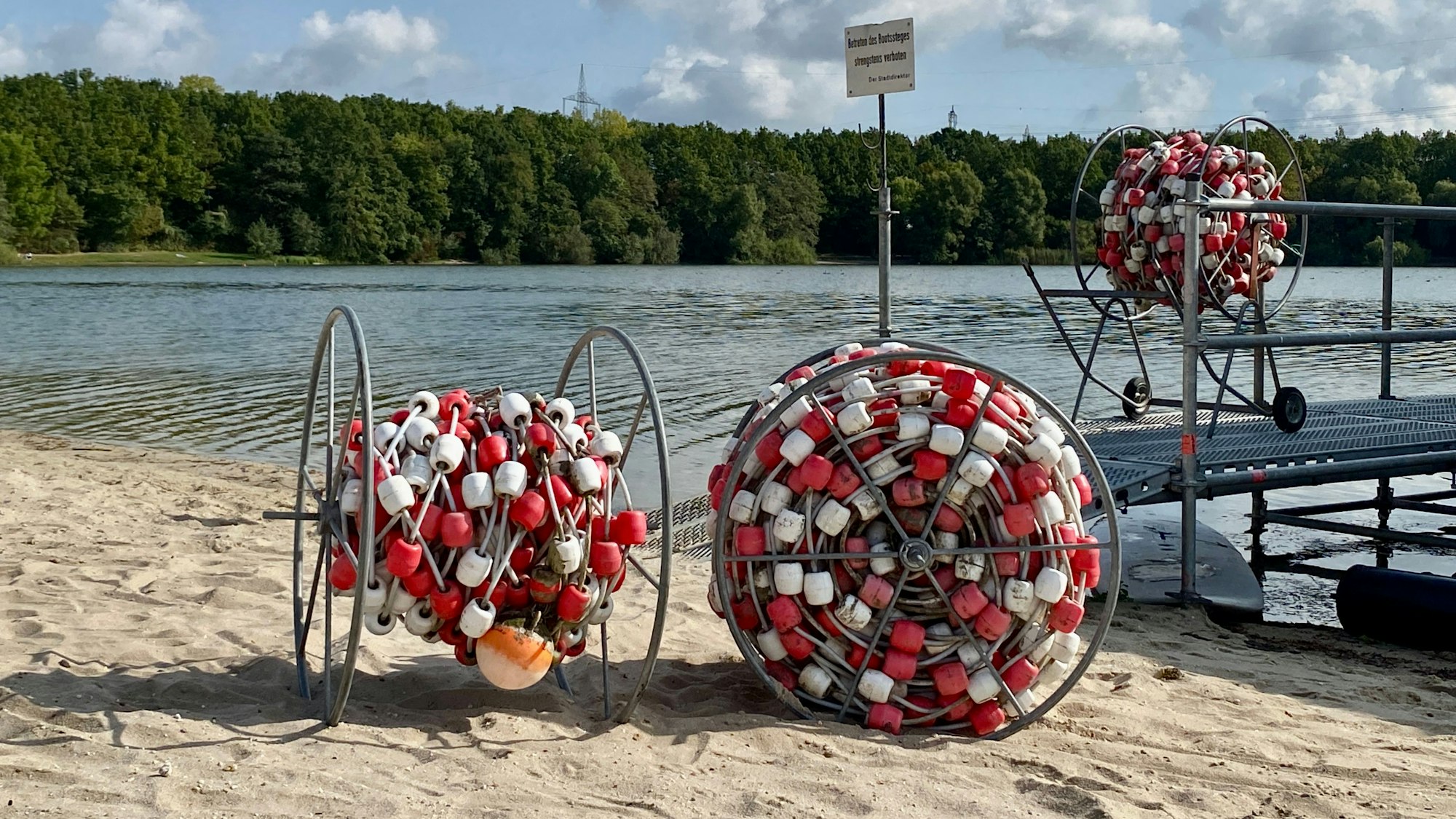 Aufgerollte Schwimmleiten am Seeufer.