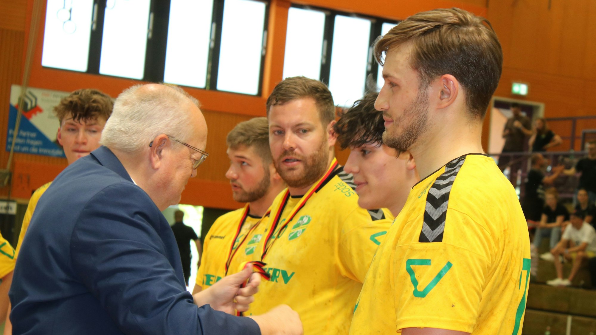 Die Handballer des HC Gelpe/Strombach stehen aufgereiht und warten darauf, die Silbermedaille zu bekommen.