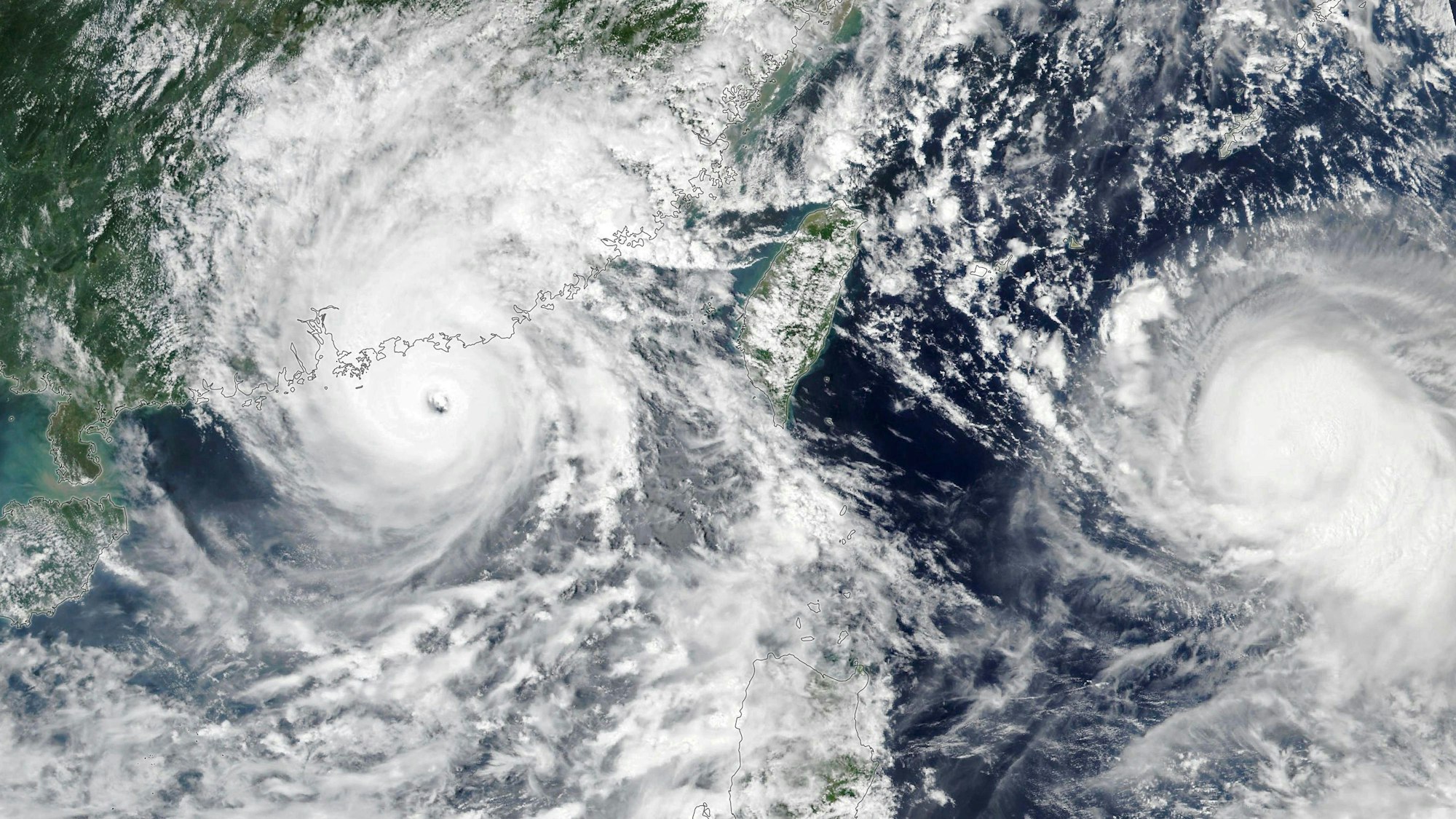 Das Satellitenbild des NOAA-NASA Suomi NPP zeigt den Taifun Saola (l), der an Hongkong vorbeizieht, als er am 1. September 2023 an der chinesischen Küste landet. Rechts, weiter draußen auf dem Meer, bewegt sich der Taifun «Haikui» westwärts in Richtung Taiwan. Foto: Suomi Npp/Noaa-Nasa/Planet Pix via ZUMA Press Wire/dpa - ACHTUNG: Nur zur redaktionellen Verwendung im Zusammenhang mit der aktuellen Berichterstattung und nur mit vollständiger Nennung des vorstehenden Credits +++ dpa-Bildfunk +++