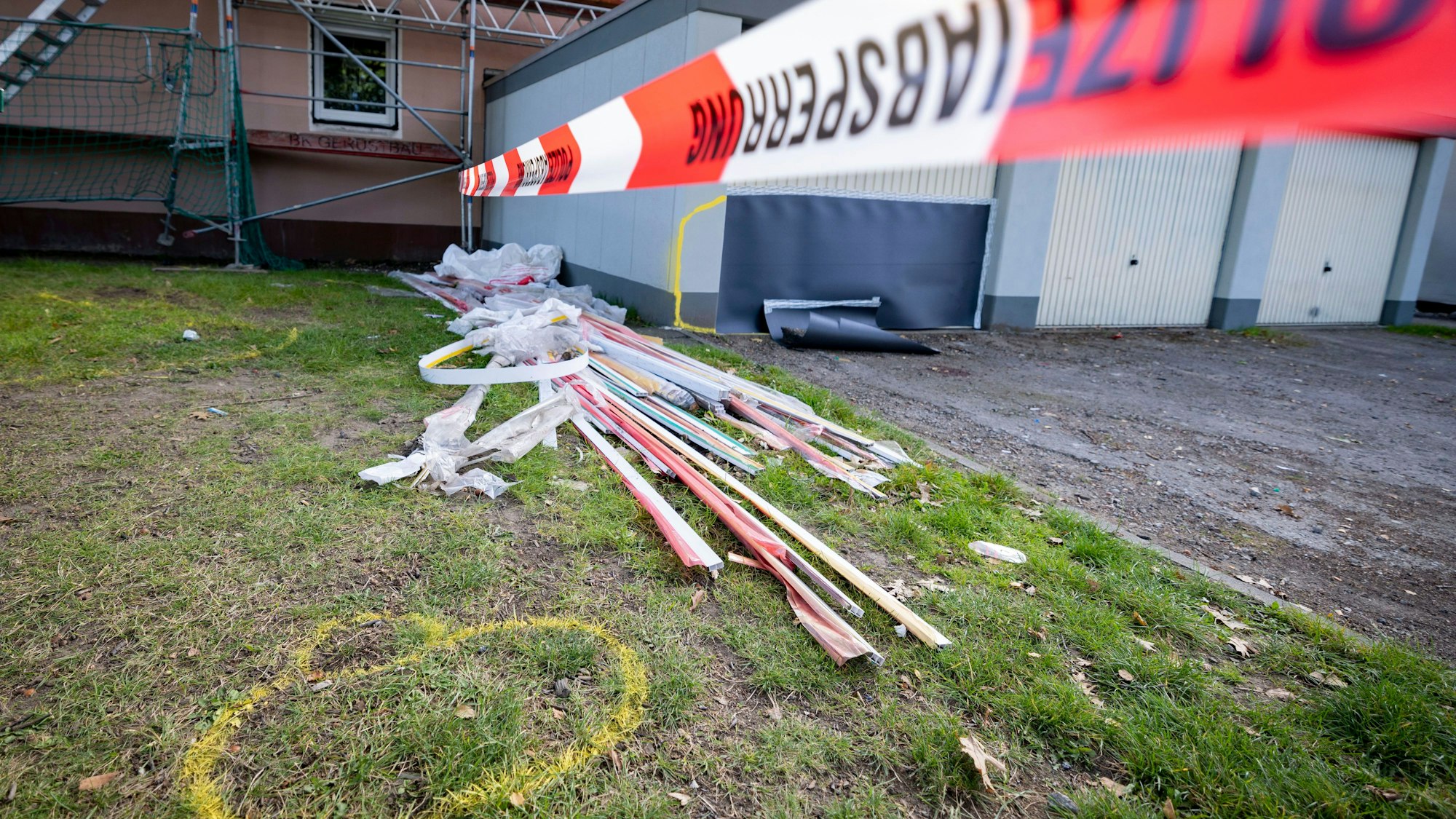 Flatterband der Polizei sperrt einen Tag nach einer Attacke eines 25 Jahre alten Mannes auf seine 19 Jahre alte Ehefrau und seinen 17 Monate alten Sohn den Tatort ab. Gelbe Markierungen zeigen Fundorte von Beweisstücken an. Die Frau verstarb, der Sohn schwebt weiterhin in Lebensgefahr. Der 25-jährige Fahrer wurde festgenommen. Eine Mordkommission ermittelt.