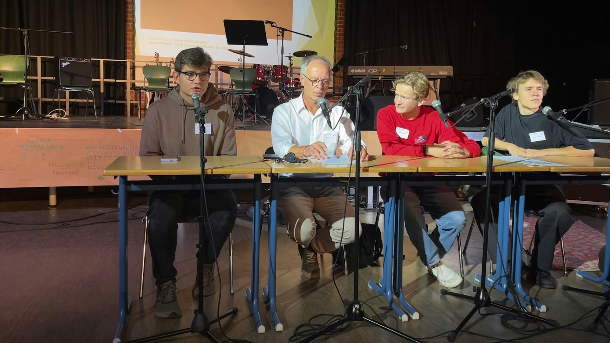 Schüler Aaron Welsch (v.l.n.r.), Schulleiter Michael Wittka-Jelen, Tom Neuburg und Jaspar Toennissen sprechen auf der Pressekonferenz über die Ergebnisse der Projektwoche.