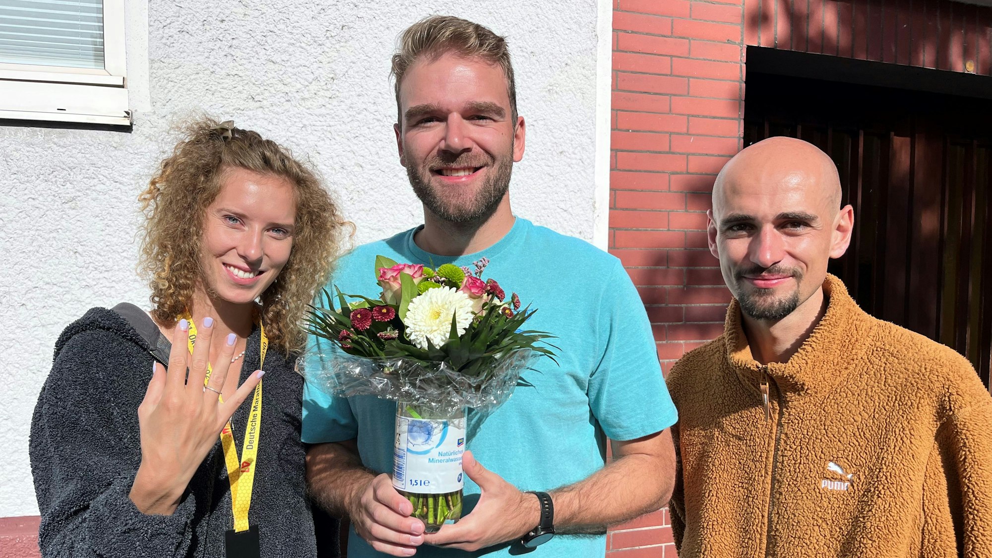 Marathon-Meisterin Esther Jacobitz hat ihren Verloberungsring wieder. Simon Breuer (Mitte) hat ihn gefunden und sicher verwahrt. Hendrik Pfeiffer ist der Verlobte und genauso happy wie seine Partnerin.