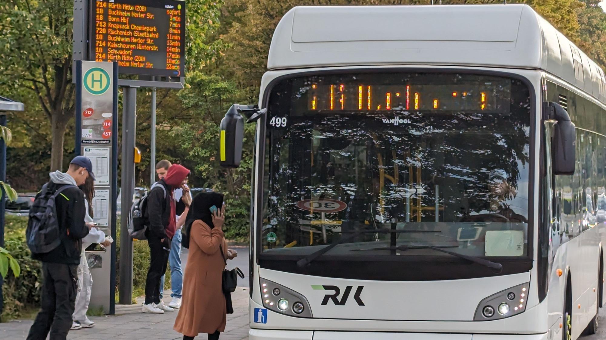 Ein Bus an einer Bushaltestelle in Hürth-Hermülheim, an der Fahrgäste warten.