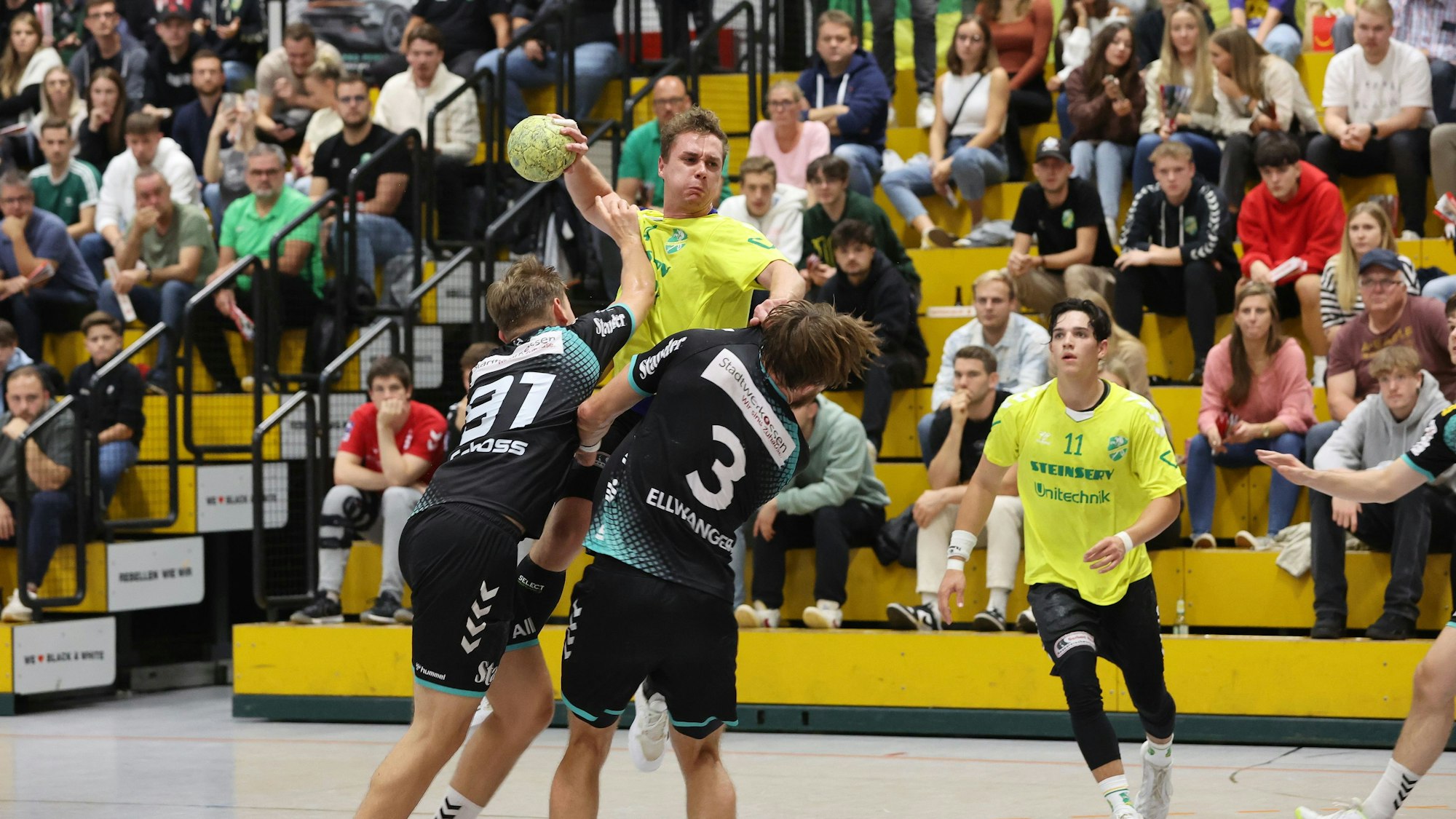 Alexandre Brüning, Spieler des HC Gelpe/Strombach, steigt über der Essener Abwehr auf und setzt zum Torwurf an.