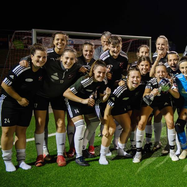 Eine Frauenfußballmannschaft jubelt über den Pokalsieg.