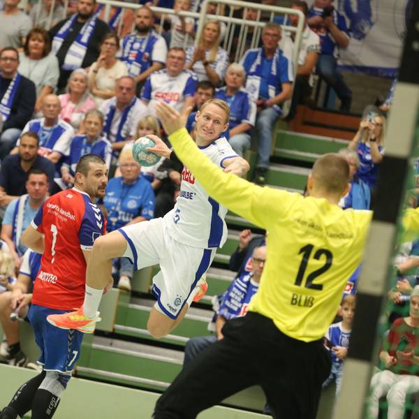 Tilen Kodrin springt mit dem Ball in der rechten Hand auf den Ratinger Torhüter zu.