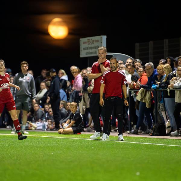 Zuschauer stehen direkt hinter dem Zülpicher Trainerduo am Spielfeldrand. Im Hintergrund der blutrote Mond.