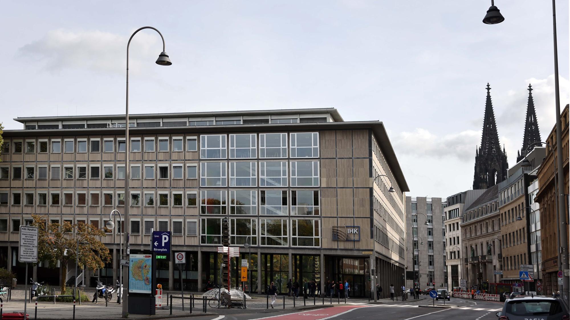 Ein Gebäude mit vielen Fenstern. Im Hintergrund sind die Türme des Kölner Doms sichtbar.