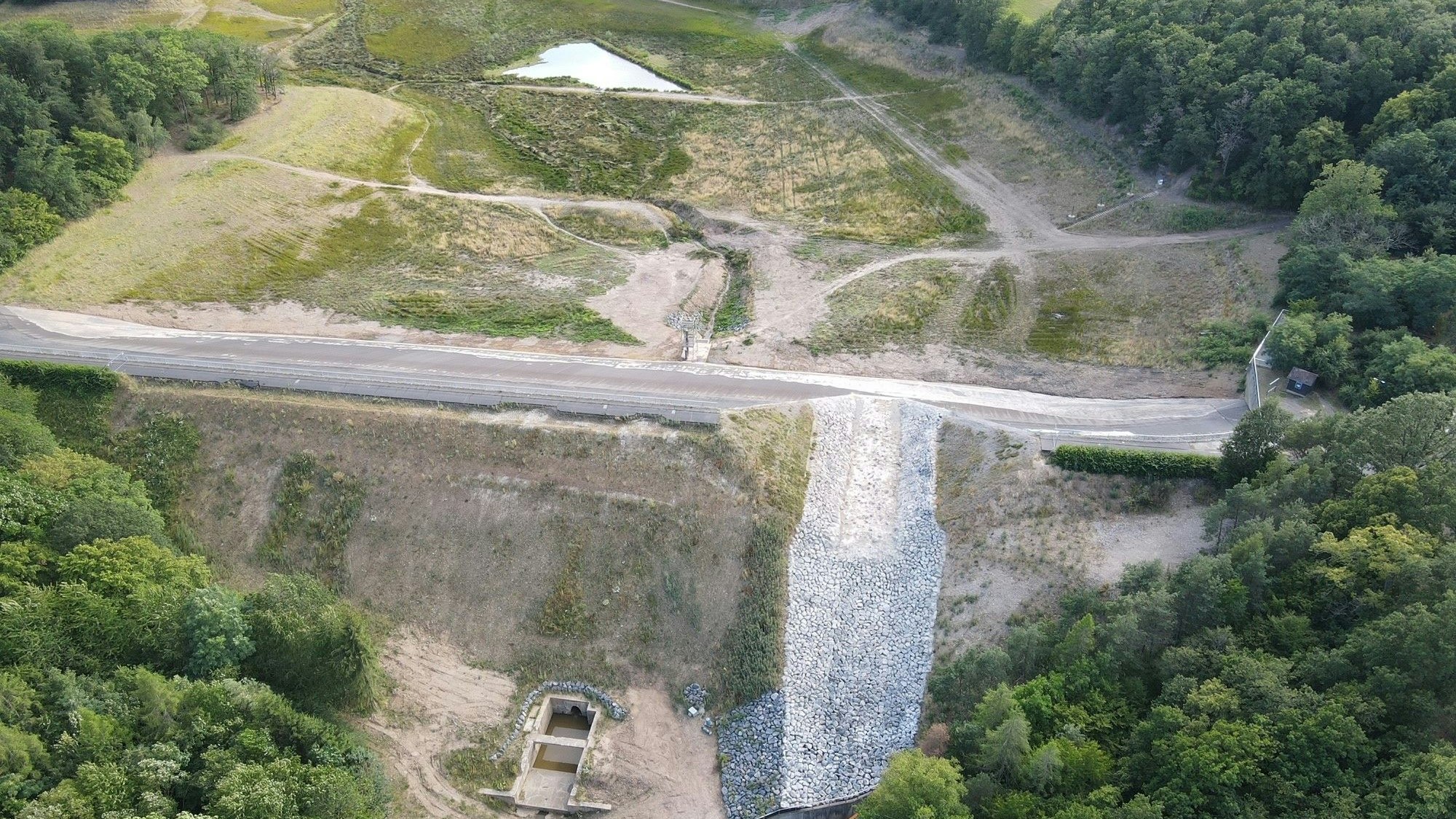 Das Bild zeigt die Steinbachtalsperre aus der Luft. Im Damm ist weiterhin ein großes Loch zu erkennen.