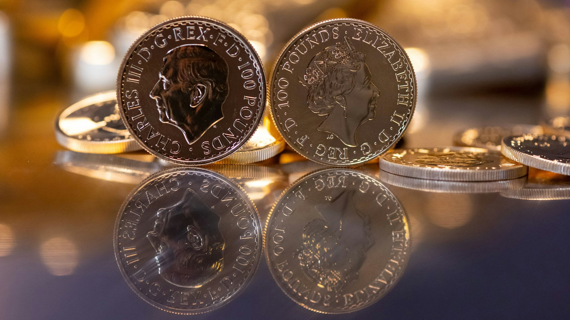 Goldbarren und Goldmünzen in unterschiedlicher Größe liegen beim Edelmetallhändler Pro Aurum in einem Tresor auf einem Tisch.
