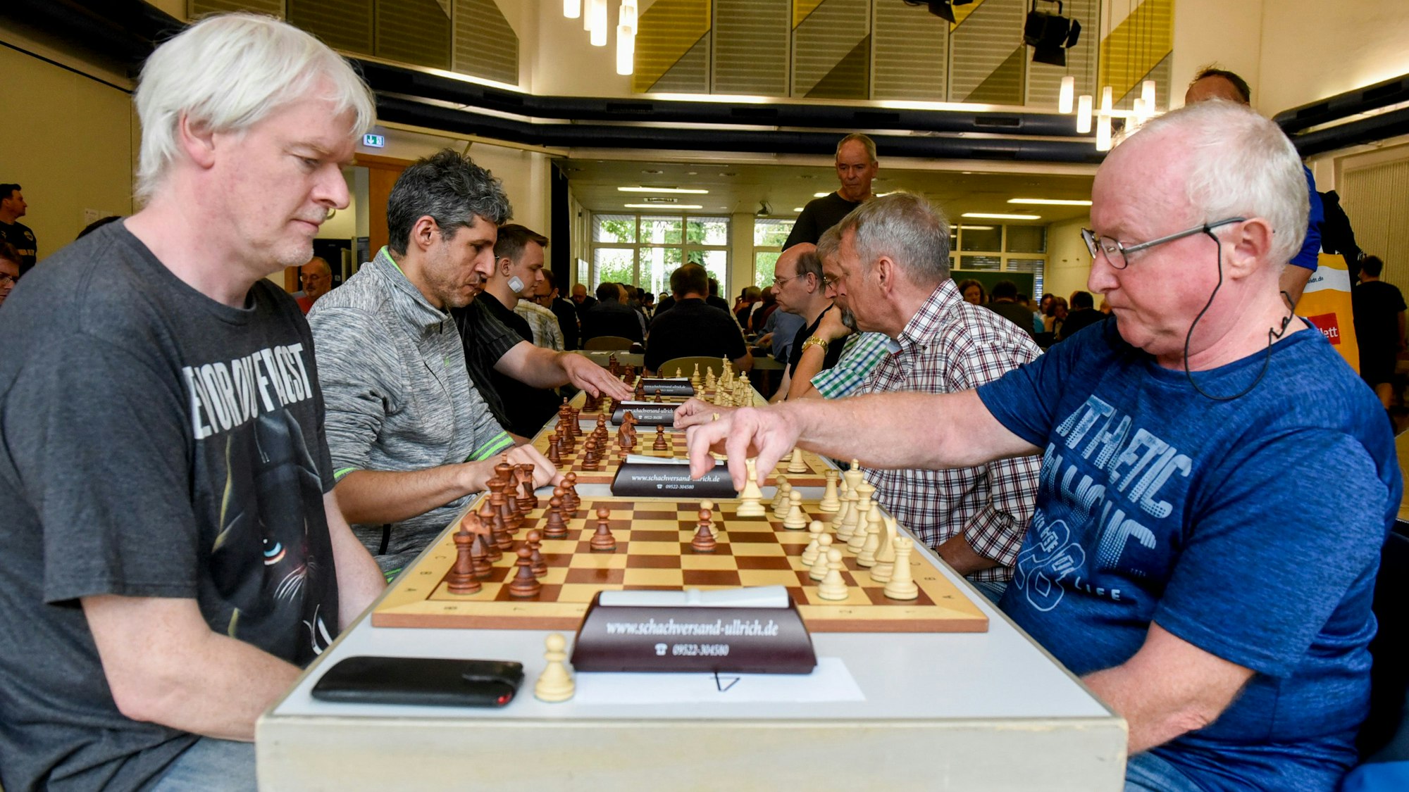 Die Schachspieler Christof Wulfken und Alois Kocur sitzen sich gegenüber und spielen Schach.